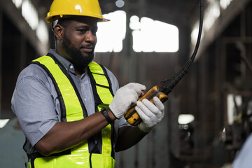 Wall Mural - African American male engineer factory worker control heavy machine in the industry factory area. Worker and manufacturing industry factory concept