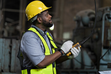 Wall Mural - African American male engineer factory worker control heavy machine in the industry factory area. Worker and manufacturing industry factory concept