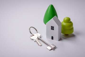 A small wooden house and keys as an idea for investing in your own home