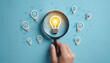 © Digital Provoke - Hand holding magnifier glass with one light bulb and idea checking icon inside it ,