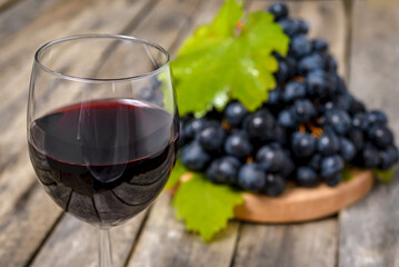 Wall Mural - Red wine and grapes on wooden background