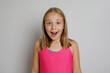 © millaf - Excited young girl portrait. Little kid posing on light gray studio background