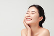 © Darya Lavinskaya - Beautiful happy young Asian woman touching her face caring for facial skin. Skincare concept