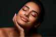 Beautiful happy young Indian woman touching her face caring for facial skin. Skincare concept