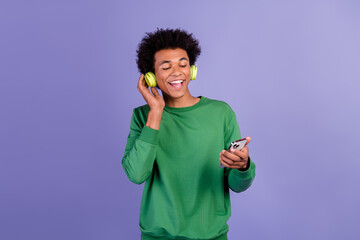 Poster - Photo of good mood dreamy man dressed green sweater earphones enjoying songs modern device isolated violet color background