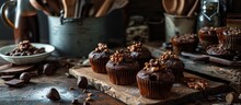 Vintage Dark Kitchen Countertop Adorned With Chocolate Ganache And Hazelnut-topped Chocolate Chip Muffins.