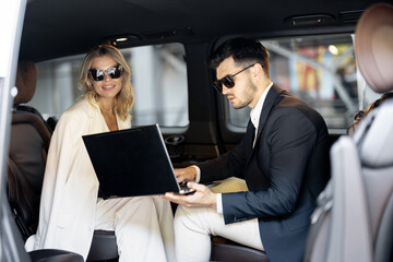 Wall Mural - Business people sitting in minivan taxi, having some business, view through an open door. Concept of business trips and transportation