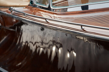 the wooden side of the luxury motor boat in port of Hercules in Monaco, sunny glare of the sun, elegance boat, glossy surfaces shine in sunny weather