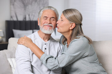 Wall Mural - Senior woman kissing her beloved man at home