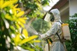 A pest control specialist in protective gear is spraying pesticides