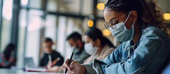 Poster - Group of diverse international students wearing protective masks and talking discussing project sitting at desk in the classroom at the university. Creative Banner. Copyspace image