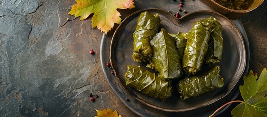 Poster - Delicious traditional oriental Turkish grape leaf dolma stuffed with rice on a red heart shaped plate. Creative Banner. Copyspace image