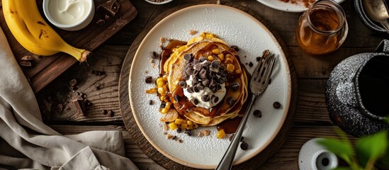 Canvas Print - Corn pancakes with caramelized bananas natural yogurt and chocolate chips on white plate Girl eating pancakes for breakfast First person view top view. Creative Banner. Copyspace image