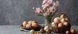Un panier rempli d'oeufs de Pâques en chocolat avec des fleurs sur fond gris