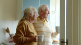Fototapeta Panele - Happy senior couple drinking coffee or tea on home kitchen