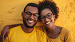couple of black man and woman wearing glasses in studio photo with clothes and yellow background.