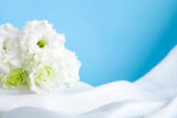 白いドレープとブルーバックに映える美しいトルコキキョウの花の素材