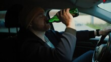 Serious Man Driver With Beer Bottle In Hand Driving Car