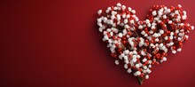 Festively decorated Valentine's Day flowers on dark red background, flat lay. space for text