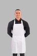© theartofphoto - Attractive chef or waiter posing, wearing white apron and black shirt on gray background, in studio shot
