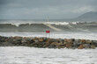 Ventura rock jetty has danger sign that is dwarfed by the high tides and large swells