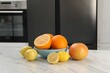 Allergenic food. Different citrus fruits on light marble table in kitchen