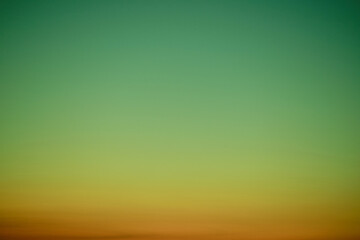 Wall Mural - Sunset sky gradient from red to green, copy space. Clear sunset sky with the bright light of the setting sun
