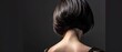  the back of a woman's head with her hair in a sleek, straight, blunted - up style.