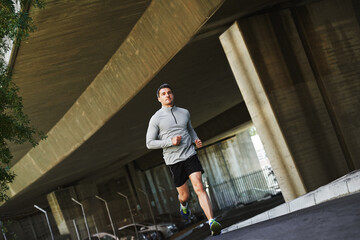 Poster - Man, runner and fitness on street in outdoors, cardio and exercise or training for marathon. Male person, athlete and workout by city background, sportswear and performance challenge on asphalt