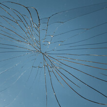 Abstract Background With Broken Mirror Glass Crack Reflecting The Blue Sky