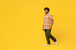 Full body side view smiling happy cheerful fun young Indian man he wears shirt casual clothes walking going looking camera isolated on plain yellow color background studio portrait. Lifestyle concept.