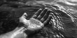 A person's hand submerged in a body of water. Can be used to represent relaxation, tranquility, or the concept of letting go
