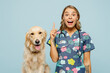 Young veterinarian woman she wear uniform stethoscope heal exam hug cuddle embrace retriever dog point finger up isolated on plain pastel light blue background studio portrait Pet health care concept
