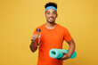 Young fitness trainer instructor sporty man sportsman wear orange t-shirt hold caremat drink water look camera spend time in home gym isolated on plain yellow background Workout sport fit abs concept
