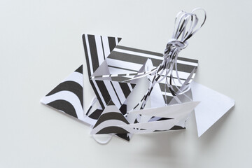 Poster - black and white paper shapes tied together in a pile