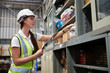 © offsuperphoto - factory worker holding a clipboard and looking at shelf in warehouse storage