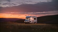 An RV Parked In A Field At Sunset