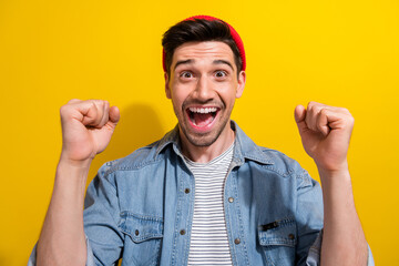 Poster - Photo of positive lucky man dressed jeans shirt screaming yes rising fists isolated yellow color background