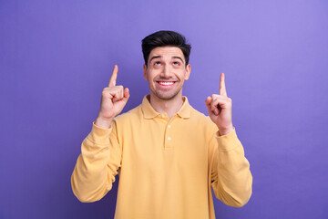 Canvas Print - Photo of dreamy excited guy wear yellow polo looking showing two fingers up empty space isolated violet color background