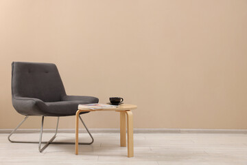 Sticker - Comfortable armchair and coffee table near beige wall indoors, space for text. Interior design