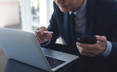 Canvas Print - Asian businessman online meeting via laptop computer by online meeting app from office, video conference. Business man working on laptop computer, searching business data for project planning