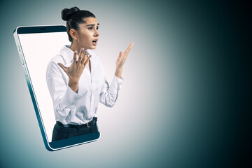 Poster - Upset young european businesswoman inside smartphone on gray background with mock up place for your advertisement. Internet communication, online video messaging and remote work concept.