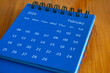 © Renrae - February 2024 table calendar on wooden desk. Time and calendar concept