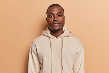 horizontal shot of handsome dark skinned african man with small beard full lips big eyes looks direc