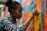 Fototapeta  - A woman artist creating a vibrant mural that pays homage to African culture and history