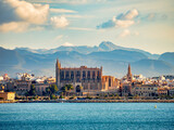 Fototapeta Perspektywa 3d - Palma, Majorca, Spain - View of Mallorca Cathedral from a ship in the harbour, against a mountain backdrop.