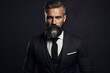 portrait of a stylish bearded man in suit with dark background
