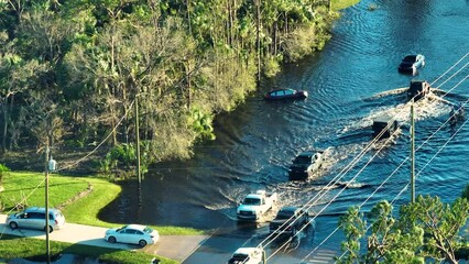 Wall Mural - Hurricane Ian flooded street with moving cars and surrounded with water houses in Florida residential area. Consequences of natural disaster