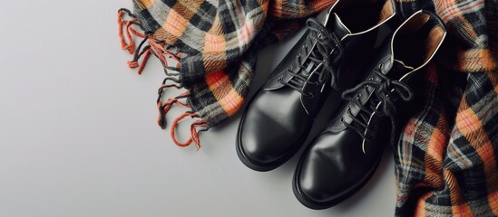 Poster - Set of women s autumn winter clothes on a light background black boots and scarf Fashionable clothes for walks flat lay. Creative Banner. Copyspace image