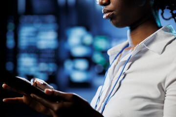 Poster - focused admin in data center uses tablet to prevent server machines overload. expert between server 